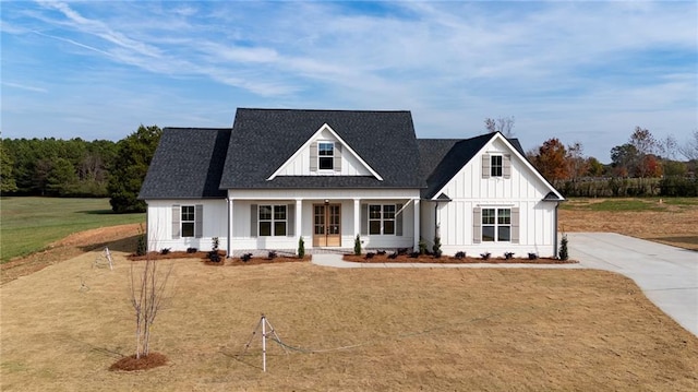 modern farmhouse featuring a porch and a front yard