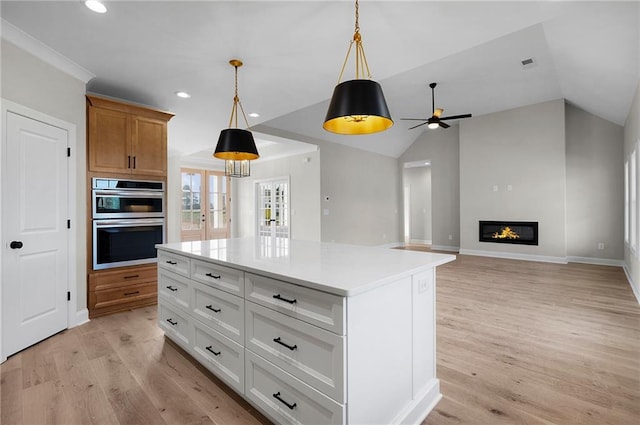 kitchen featuring white cabinets, pendant lighting, a kitchen island, and lofted ceiling