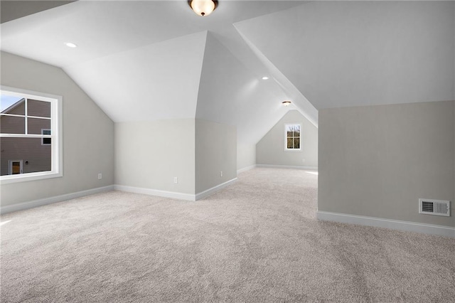 bonus room featuring lofted ceiling and light carpet