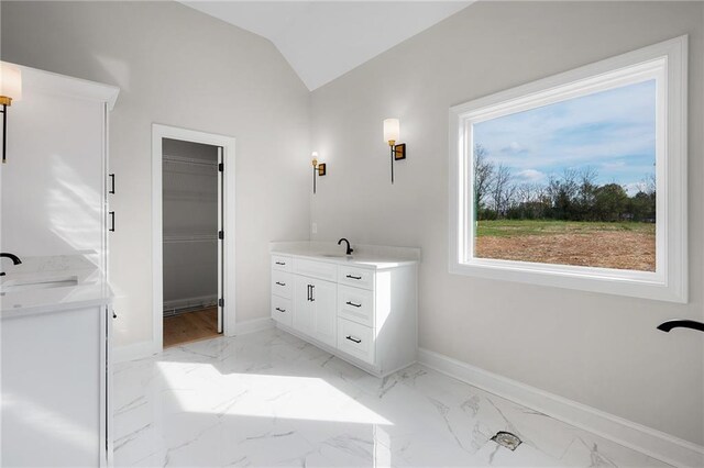 bathroom featuring vanity and lofted ceiling