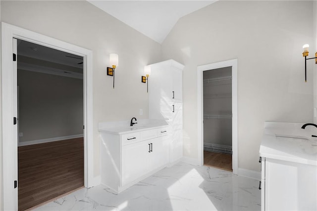 bathroom with hardwood / wood-style floors, vanity, and vaulted ceiling