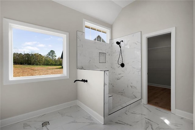 bathroom with lofted ceiling and tiled shower