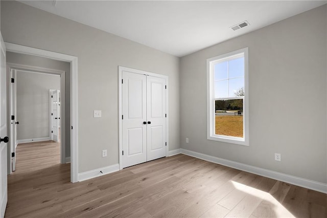 unfurnished bedroom featuring light wood-type flooring and a closet