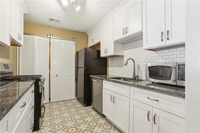 kitchen with a sink, visible vents, appliances with stainless steel finishes, and white cabinets