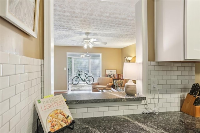 interior space featuring a textured ceiling, tile walls, and a ceiling fan