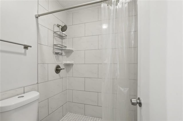 full bath featuring toilet and a tile shower