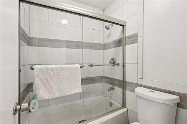 full bath featuring shower / bath combination with glass door and toilet