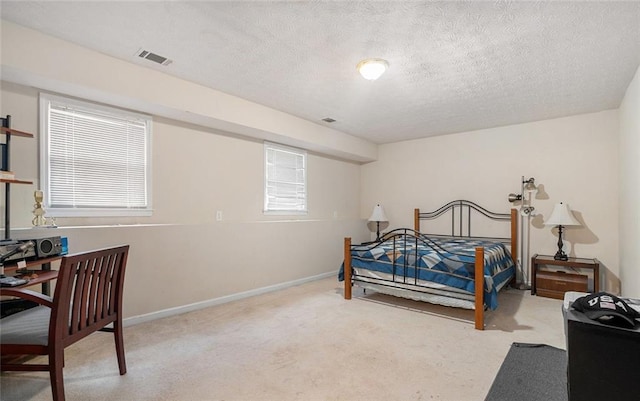 carpeted bedroom featuring a textured ceiling and multiple windows