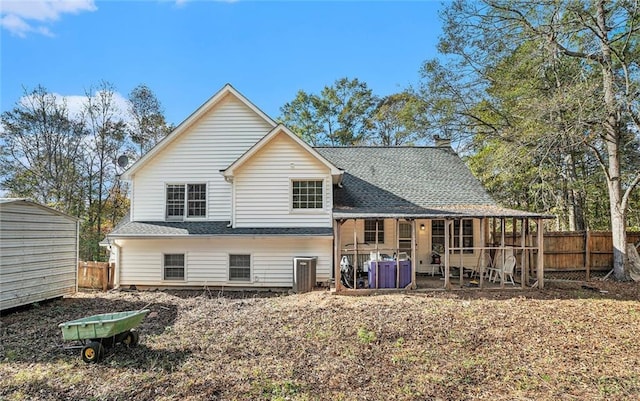 rear view of house featuring a storage unit and a patio