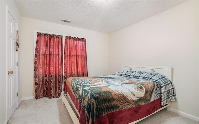 carpeted bedroom featuring a textured ceiling