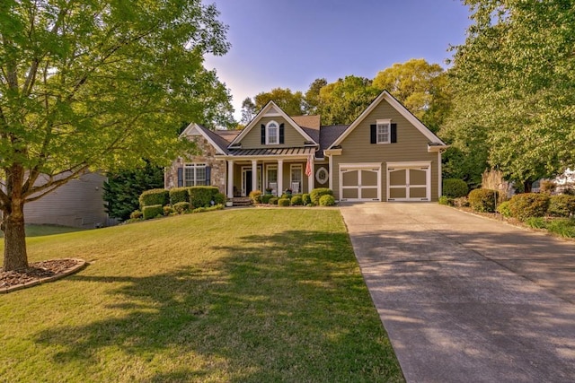 view of front of house featuring a porch, a front lawn, and a garage