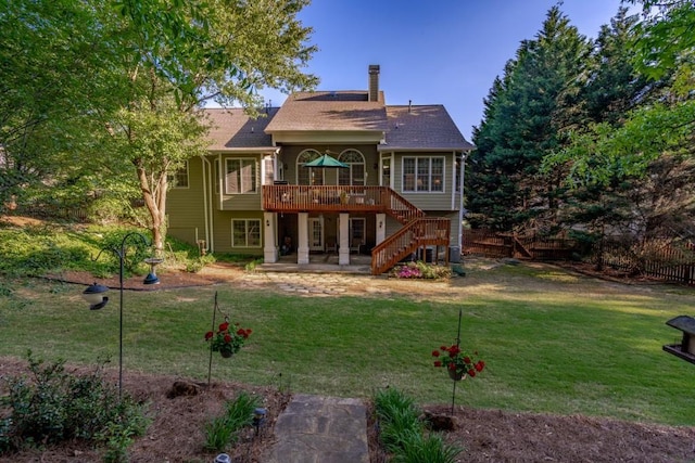 rear view of house featuring a yard and a wooden deck