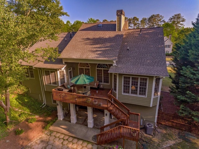 back of house featuring central AC unit, a deck, and a patio