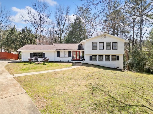 split level home with brick siding and a front lawn