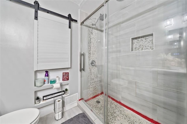 bathroom with toilet and a stall shower