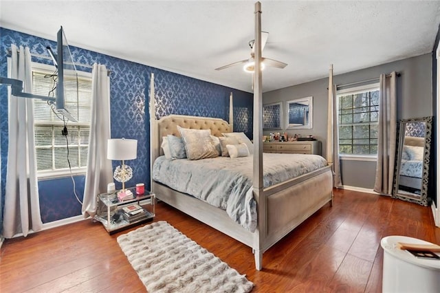 bedroom featuring baseboards, wallpapered walls, ceiling fan, wood-type flooring, and a textured ceiling