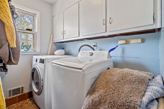 washroom with washer and dryer, visible vents, and cabinet space