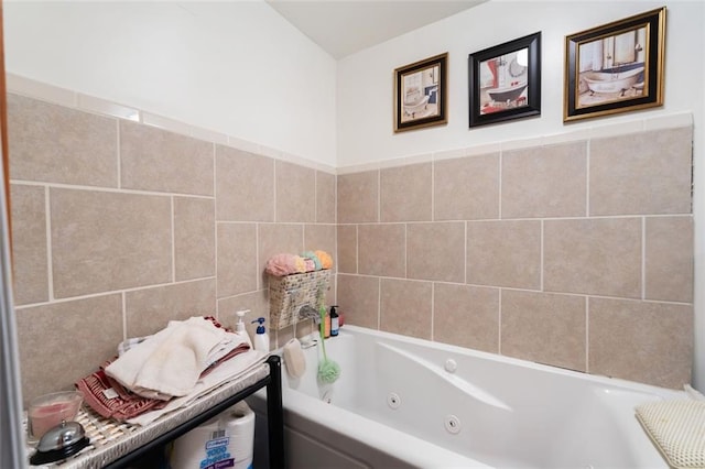 bathroom featuring tile walls and a tub with jets