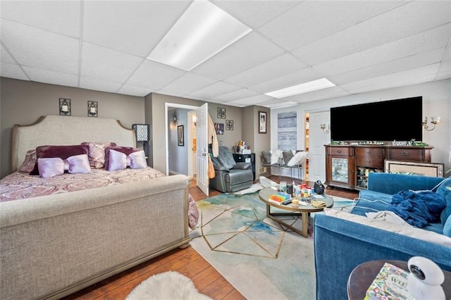 living room with a paneled ceiling and wood finished floors