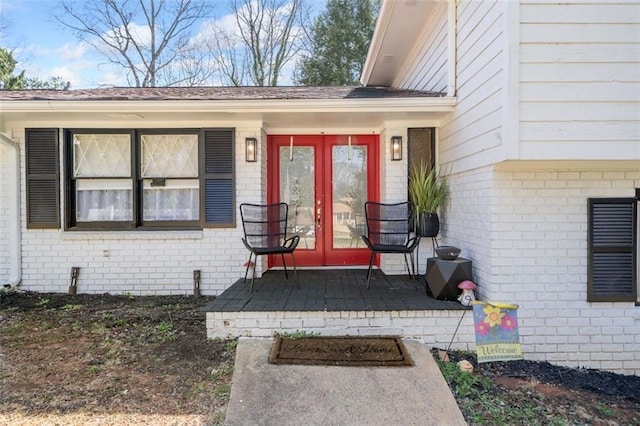 doorway to property featuring brick siding and french doors