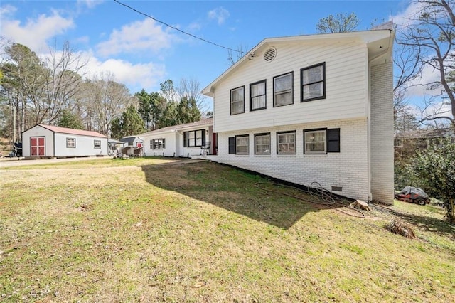 rear view of property featuring a yard and brick siding