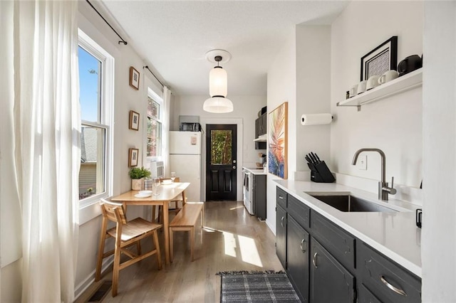 66 Howell St NE, Atlanta, GA 30312 - kitchen featuring freestanding refrigerator, a sink, light wood-type flooring, dark cabinets, and light countertops
