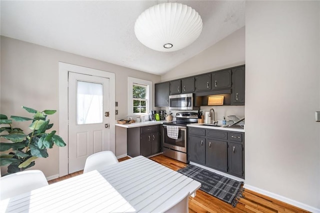 66 Howell St NE, Atlanta, GA 30312 - kitchen featuring appliances with stainless steel finishes, a sink, light wood-style flooring, light countertops, and lofted ceiling