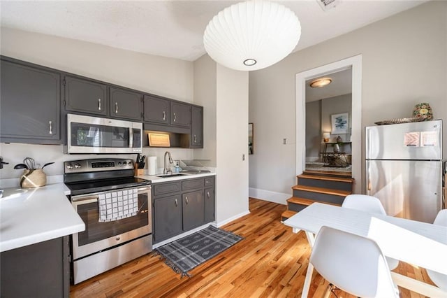 66 Howell St NE, Atlanta, GA 30312 - kitchen with stainless steel appliances, a sink, light countertops, light wood-style floors, and lofted ceiling