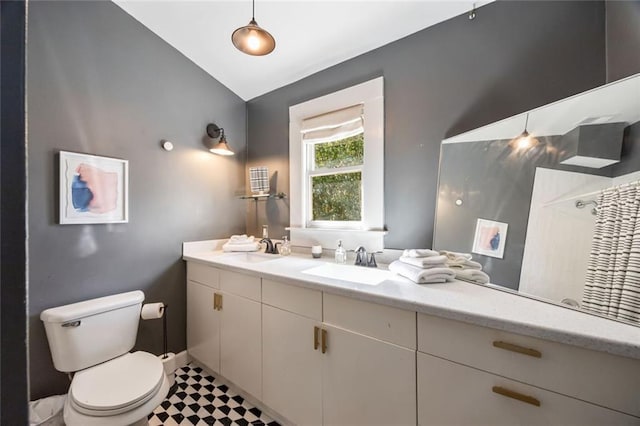 66 Howell St NE, Atlanta, GA 30312 - bathroom with vaulted ceiling, double vanity, toilet, tile patterned floors, and a shower