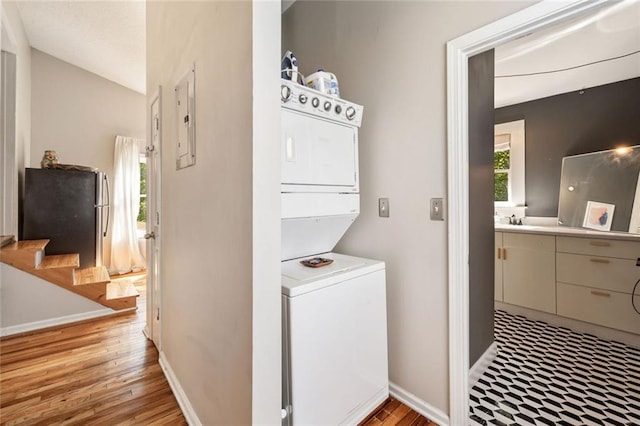 66 Howell St NE, Atlanta, GA 30312 - laundry room featuring estacked washer and dryer, light wood-style flooring, and baseboards