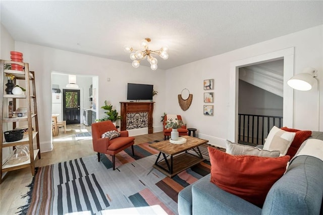 66 Howell St NE, Atlanta, GA 30312 - living room with light wood-style flooring, a chandelier, and baseboards