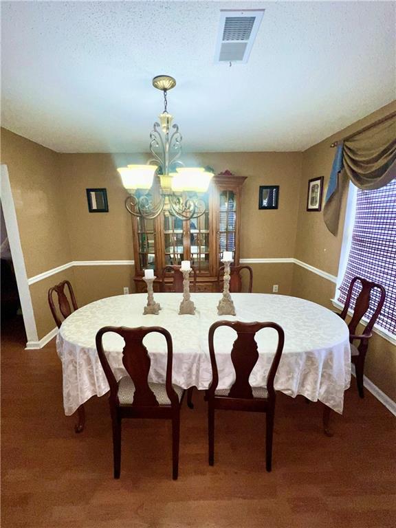 dining area with a notable chandelier and a textured ceiling