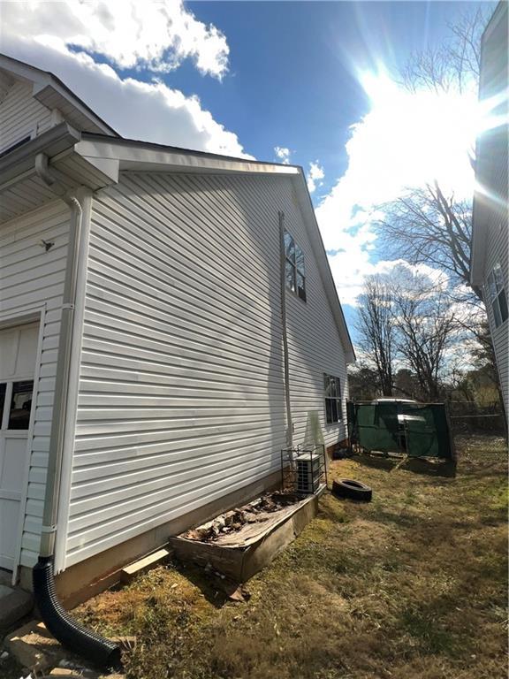 view of home's exterior with a garage and central AC