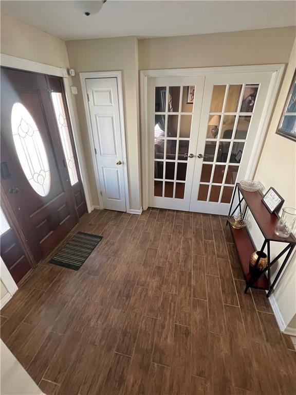 entryway with dark hardwood / wood-style floors and french doors