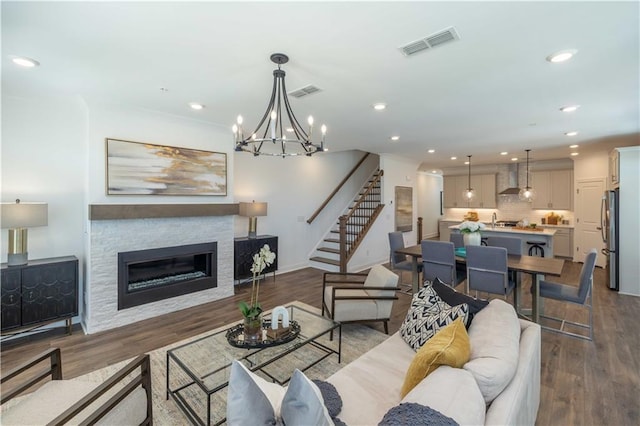 living room with stairway, a glass covered fireplace, recessed lighting, and visible vents