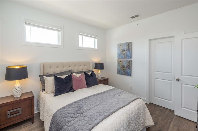 bedroom with dark hardwood / wood-style floors