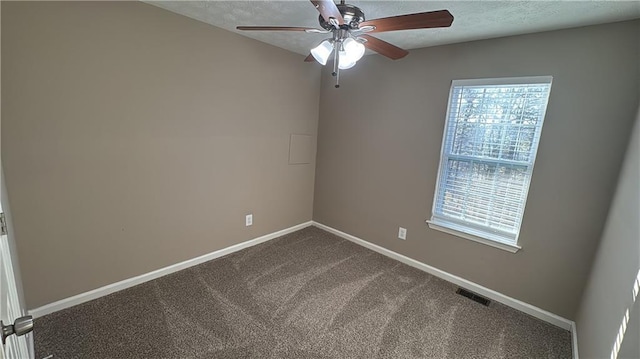 carpeted spare room with ceiling fan and plenty of natural light