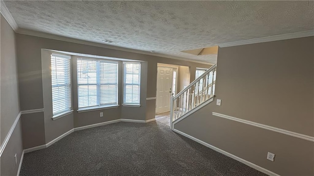 spare room featuring a textured ceiling, ornamental molding, and a healthy amount of sunlight