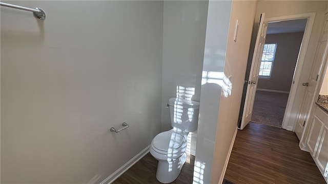 bathroom featuring toilet, vanity, and hardwood / wood-style floors