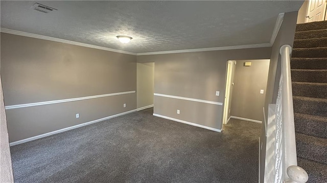 spare room with a textured ceiling, dark colored carpet, and ornamental molding