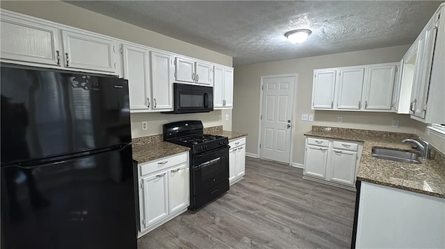 kitchen featuring sink, white cabinets, and black appliances