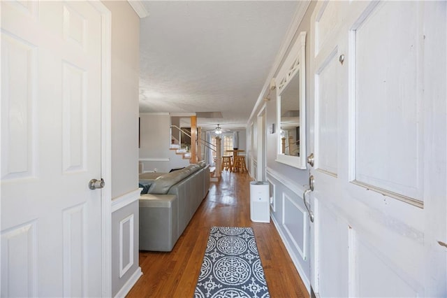 entryway featuring stairway, ornamental molding, a ceiling fan, and wood finished floors