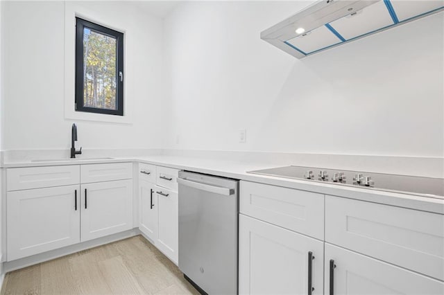 kitchen featuring stainless steel dishwasher, white cabinets, sink, and light hardwood / wood-style flooring