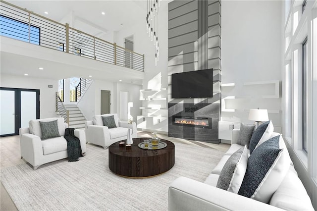 living room featuring light wood-type flooring, a fireplace, and a high ceiling