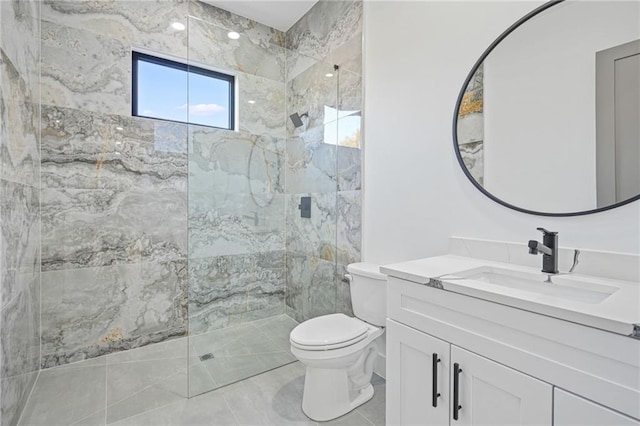 bathroom with toilet, vanity, and a tile shower