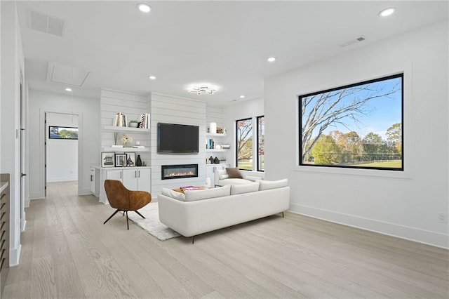 living room featuring a large fireplace and light hardwood / wood-style flooring