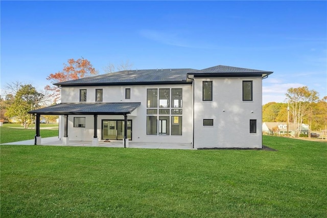 rear view of house with a lawn and a patio