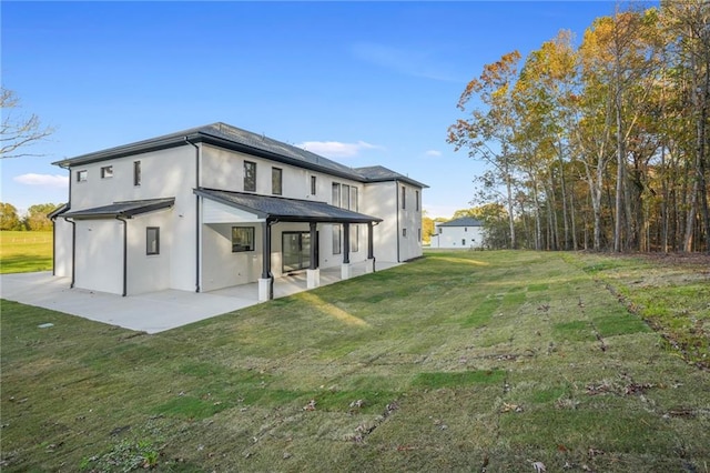 rear view of property featuring a patio area and a yard