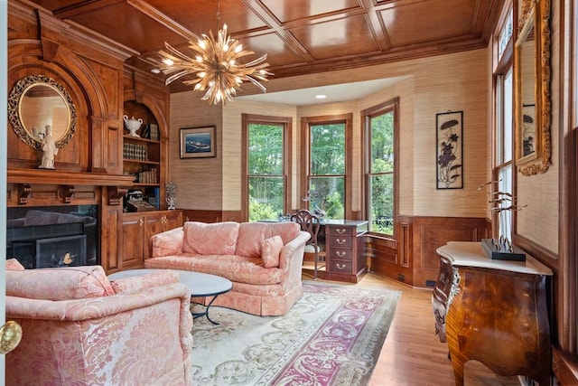 living room featuring crown molding, light hardwood / wood-style flooring, and a notable chandelier