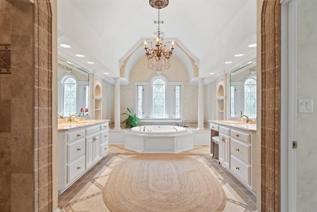 bathroom with tile patterned floors, lofted ceiling, vanity, and a bathing tub